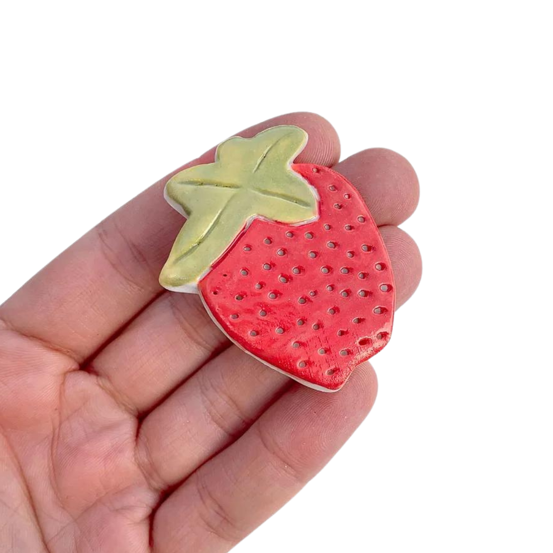 Strawberry brooch by Togetherness design. The Strawberry brooch features a hand built ceramic piece that will add a touch of colour to your outfit. Features a silver metal clasp on the reverse. As every ceramic piece has been made by hand they are each unique and