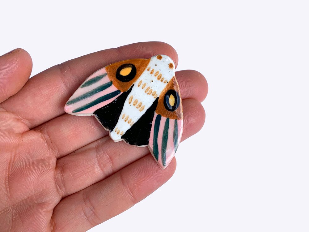 Togetherness design -The Midnight Moth brooch features a hand built ceramic piece that will add a touch of colour to your outfit. Features a silver metal clasp on the reverse. As every ceramic piece has been made by hand they are each unique and may slightly differ from pictures in terms of shape and colour.
