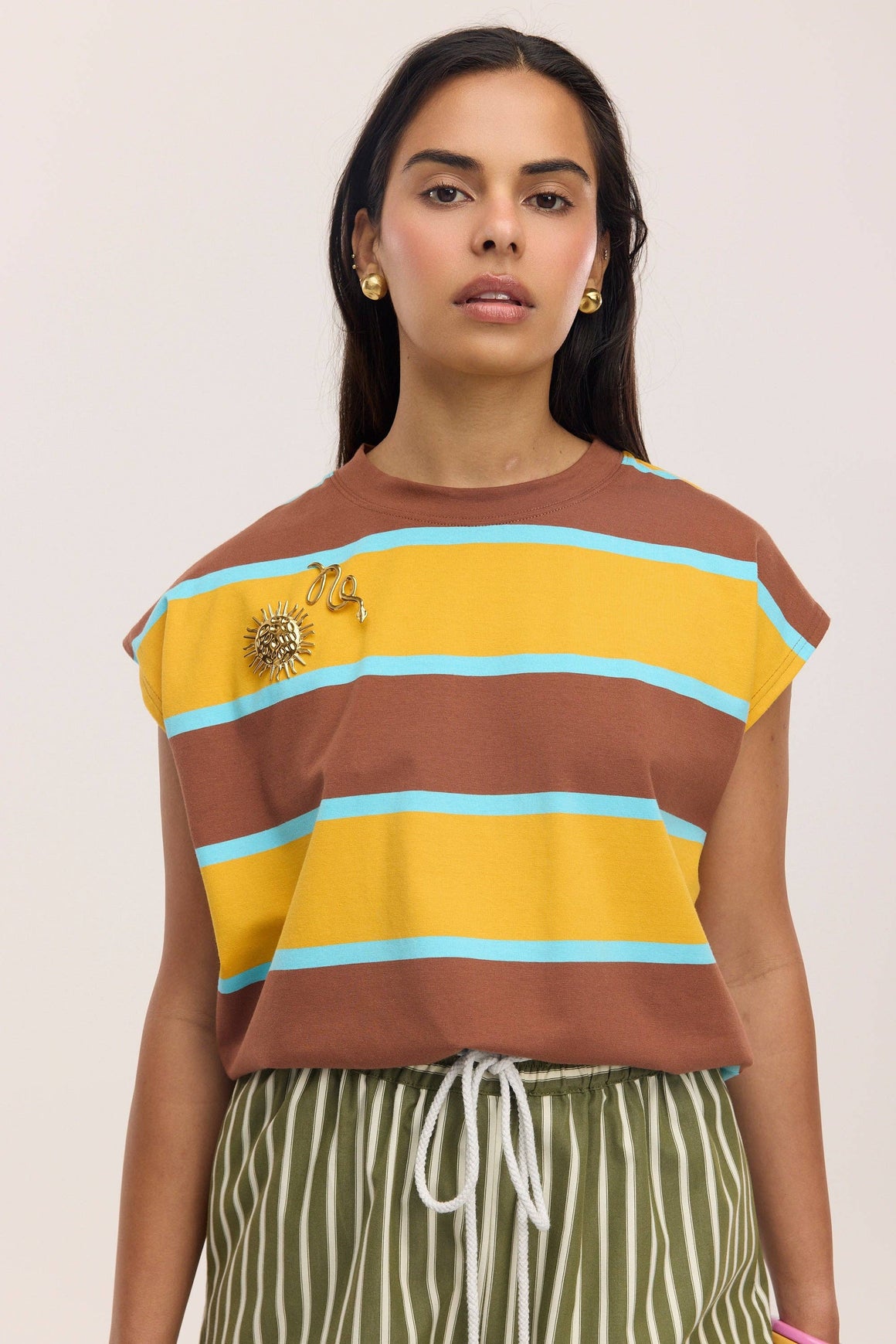 Gold sun-shaped decorative item on a white background