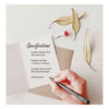 Greeting card with a bird design on a black background, placed on a brown envelope.