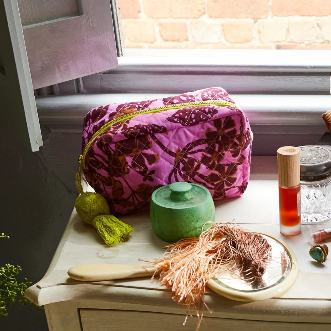 Contrasting chartreuse zipper and pom pom tassel with pink quilted fabric is a standout from this collection
