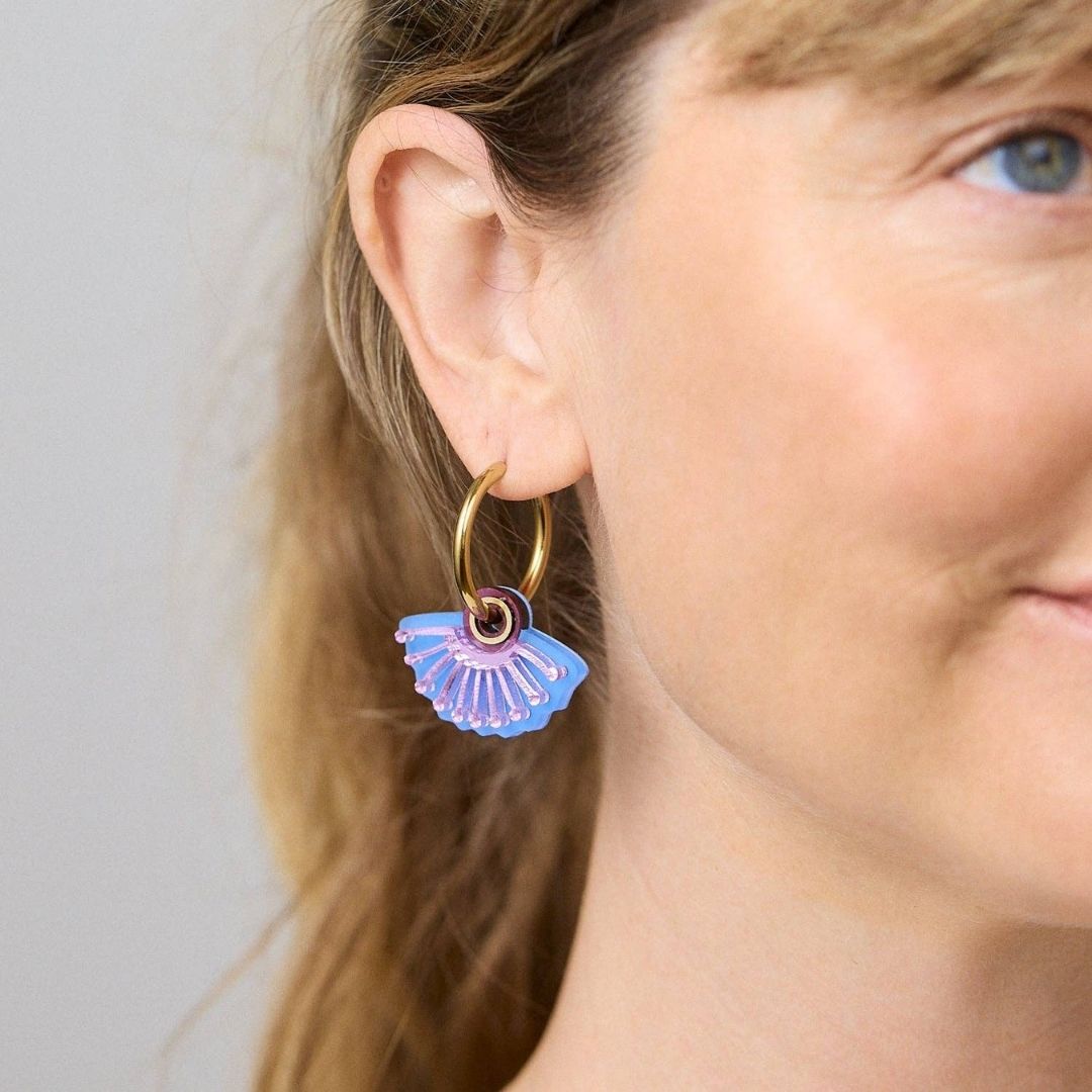 Pair of hoop earrings with blue and pink fan-shaped charms on a white background