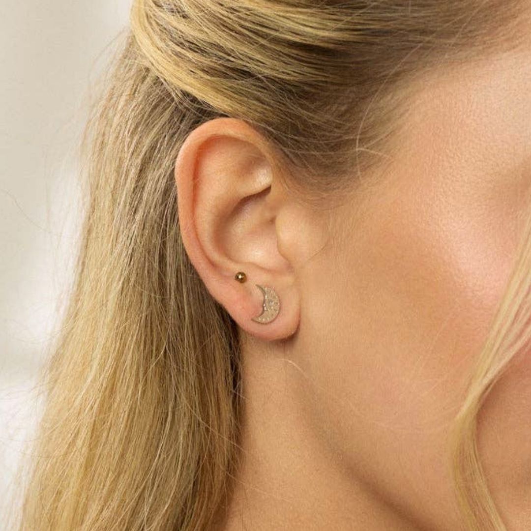 Silver sun and moon earrings on a white background