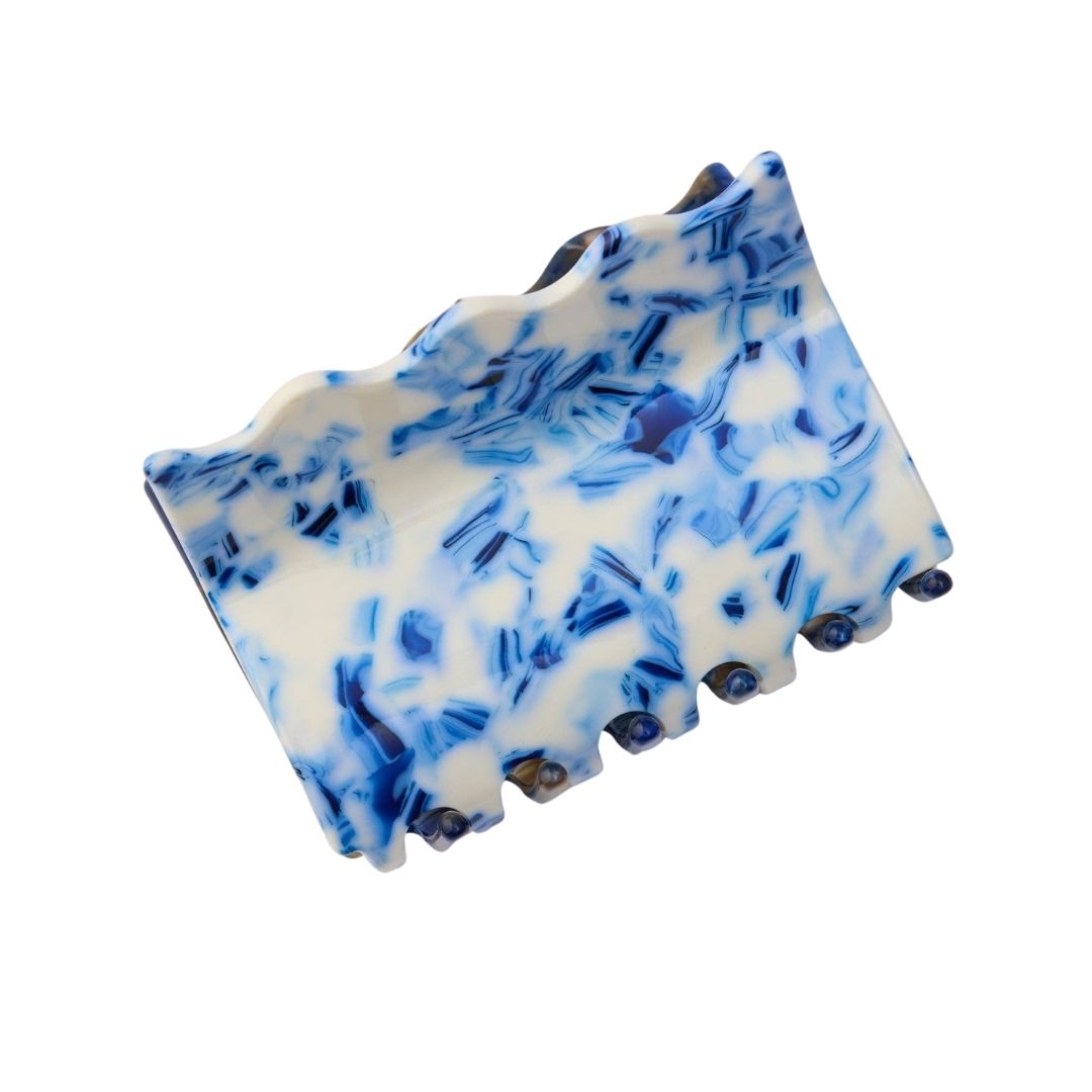 Blue and white marbled hair clip on a white background