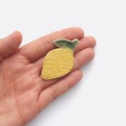 Togetherness design -The lemon brooch features a hand built ceramic piece that will add a playful touch to your outfit. Features a silver metal clasp on the reverse.